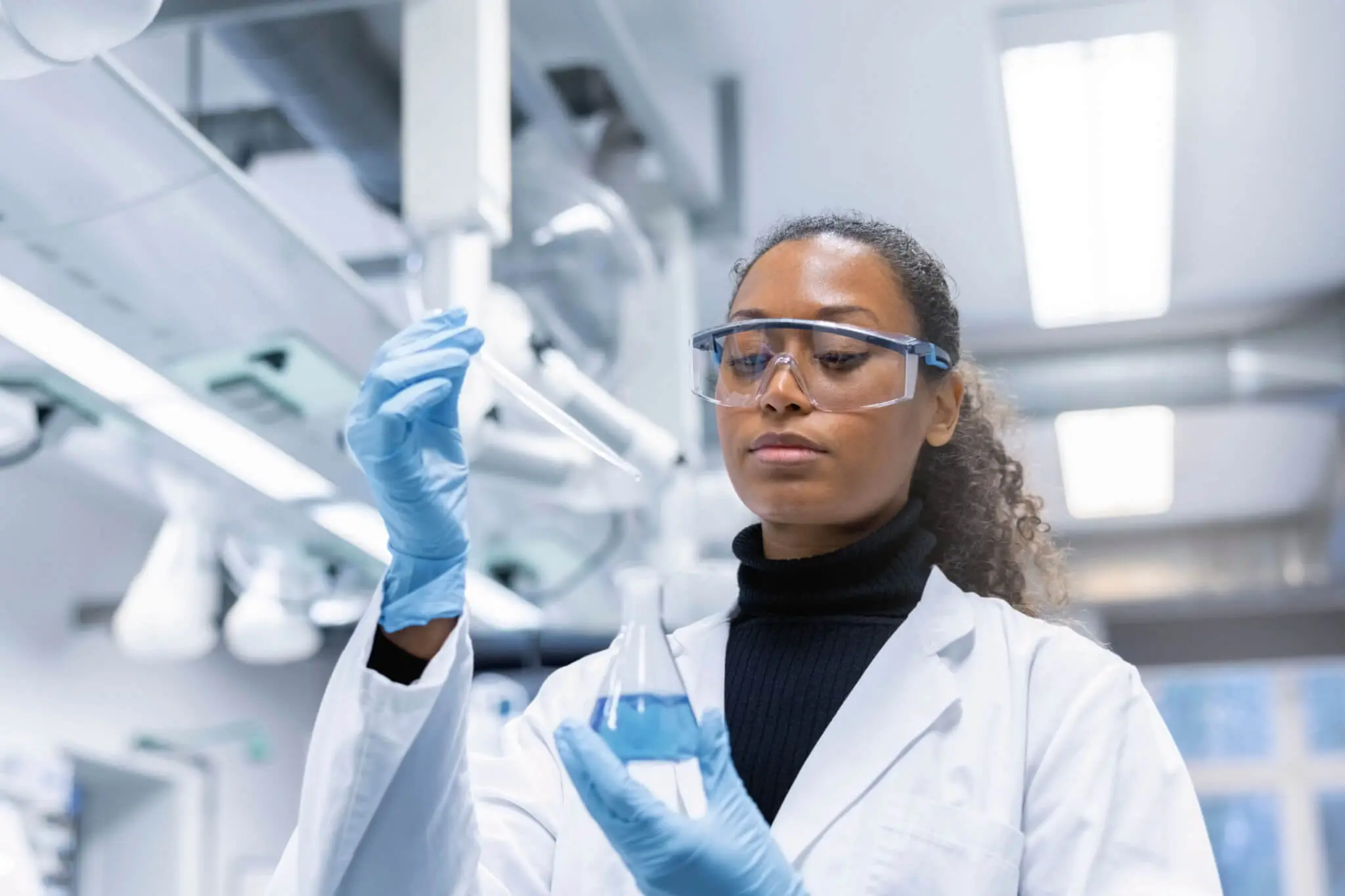 Scientist examining liquid in a laboratory.